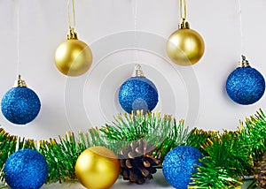 Christmas tree decorations blue and yellow balls on white background close up.