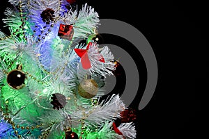 Christmas tree with decorations. Christmas tree on a dark background. Empty space for a logo.
