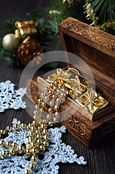 Christmas-tree decorations and goldish garland in carved wooden photo
