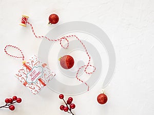 Christmas tree decorations. Red beads with a large xmas toys and gift box. Top view festive background for winter banner