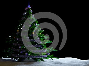 Christmas tree with decorations and snow on isolate black