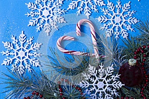 : christmas tree and decorations, top view, on a blue background, snowflakes and lollipop , cane light in claus