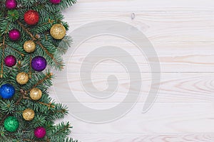 Christmas tree with decorations on wooden background. Happy new year gift card with fir branch and shiny balls, festive spheres.