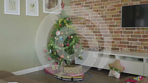Christmas tree with decorative light. gift boxes and toy steam engine on floor.