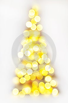 Christmas tree defocused with lights glowing on white background