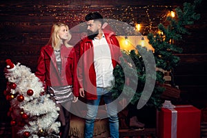 Christmas tree. Fashion couple over Christmas tree lights background. Having a crazy day with friend. Expression and