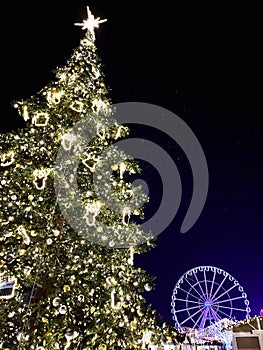 Christmas tree with Ferris wheel in the background at a Christmas market photo
