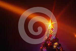 Christmas tree with festive lights, orange background with mist