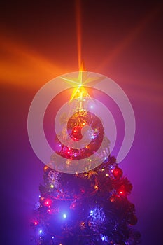 Christmas tree with festive lights, purple background with mist