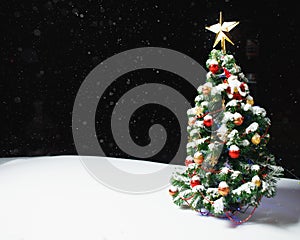 Christmas tree with festive lights in snow outdoors, black night background