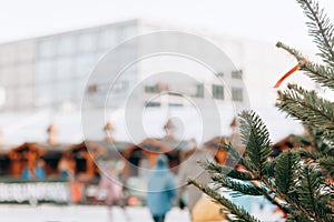 Christmas tree or fir branches in the foreground. The skating rink in Berlin in Alexanderplatz is blurred in the