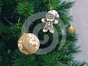 Christmas Tree fir close up decoration with big glitter golden white ball snow flake and cookies run doll selective focus.