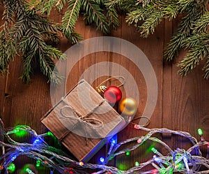 Christmas tree with gift box and decorations on wooden background