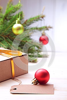 Christmas tree with gift box and decorations on wooden background