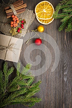 Christmas tree with gift box and decorations on wooden background