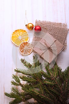 Christmas tree with gift box and decorations on wooden background