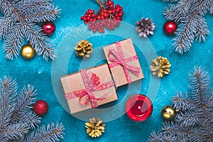 Christmas tree with gifts on a blue background. Happy New Year composition with red and gold balls, fir branches, a burning candle