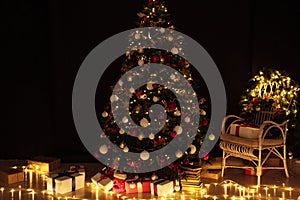 Christmas tree with gifts of garland lights for the new year in the interior of the night room as a backdrop