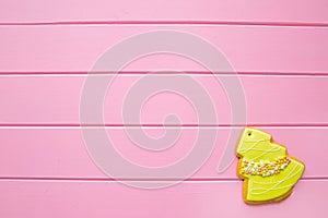 Christmas tree gingerbread cookie with sprinkles, on pink wooden table. copy space