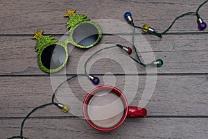 Christmas tree glasses, christmas lights and red cup of coffee