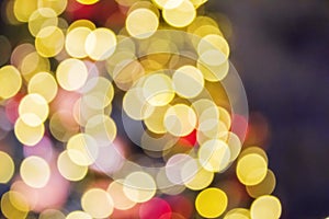 Christmas tree with golden and red decorations and lights, blurred abstract holiday background