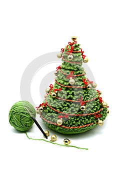 Christmas tree with goldnen balls crochet of wool. white isolated background. wool ball and crochet hook aside