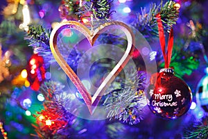 Christmas tree with heart shape decoration and purple illumination