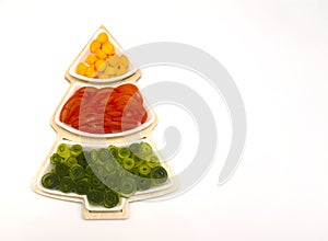 Christmas tree, holiday food for children. Vegetables and fruits are cut in a vase in the form of a Christmas tree.