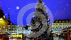 Christmas tree holiday in Tallinn old town square night city blurring light and snowflakes fall