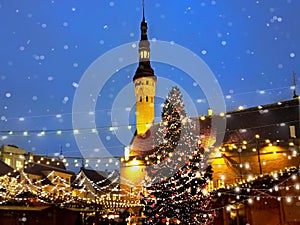 Christmas  tree holiday in Tallinn old town square night city blurring light and snowflakes fall