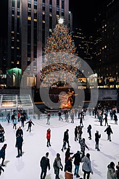 Christmas tree and ice skating rink at Rockefeller Center at night, in Midtown Manhattan, New York City