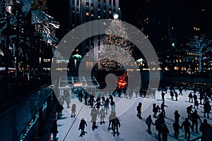 Christmas tree and ice skating rink at Rockefeller Center at night, in Midtown Manhattan, New York City