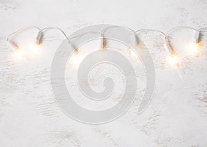 Christmas tree lights on white shabby background.