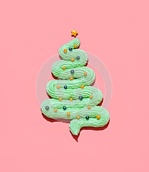 Christmas tree made from buttercream frosting isolated on a pink background