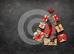 Christmas tree made from Christmas gifts and decorations on black background. Creative winter holiday concept. Flat lay