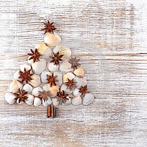 Christmas tree made from different type of sea shells and starfish with on wooden background. Sea shells shaped as a Christmas tre