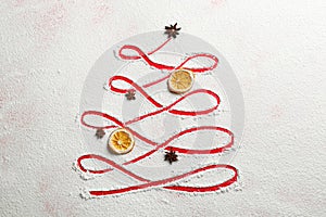 Christmas tree made of flour, orange and anise on red background, flat lay