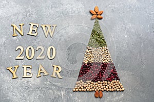 Christmas tree made of food on gray background. New year 2020. Creative idea, concept of vegetarian and vegan food. Top view, flat