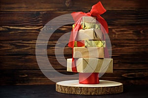 Christmas tree made from gift boxes with decorations against brown wooden background. Copy space.  Merry christmas and happy new