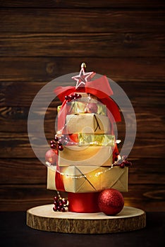 Christmas tree made from gift boxes with decorations against brown wooden background. Copy space.  Merry christmas and happy new