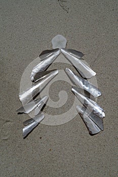 Christmas tree made of mother  of pearl shells on the white sand  background. Christmas and New  year  concept.