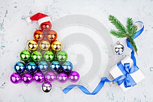 Christmas tree made of shiny decorations balls LGBT community rainbow flag colors, Santa Claus hat, gift box, blue ribbon, pine