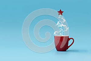 Christmas tree made of steaming coffee with red star. Morning drink. Christmas or New Year celebration concept. Copy space
