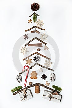 The Christmas tree is made of twigs and decorated with gingerbread, spices, caramel cane, gift boxes, cones and wooden toys on a w