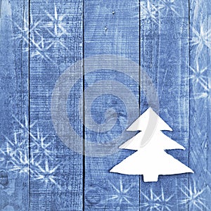 Christmas tree made from white felt on wooden, blue background. Snow flaks image. Christmas tree ornament, craft