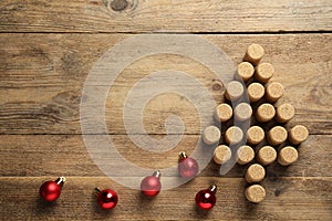 Christmas tree made of wine corks and baubles on wooden table, top view