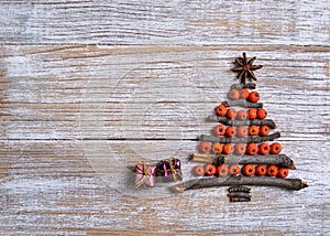 Christmas tree made of wooden branches and rowan berries. New Year celebration concept with Christmas tree with star