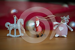 Christmas tree ornaments sitting on a wooden table with a red background