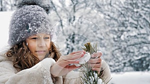 Christmas tree outdoor decoration. cutie, pretty little girl decorates snow-covered Christmas tree with homemade ice