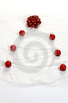 Christmas tree painted in snow with red bow and red matt christmas balls photo